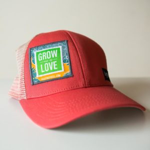 a salmon colored hat with "grow what you love" embroidered on the face